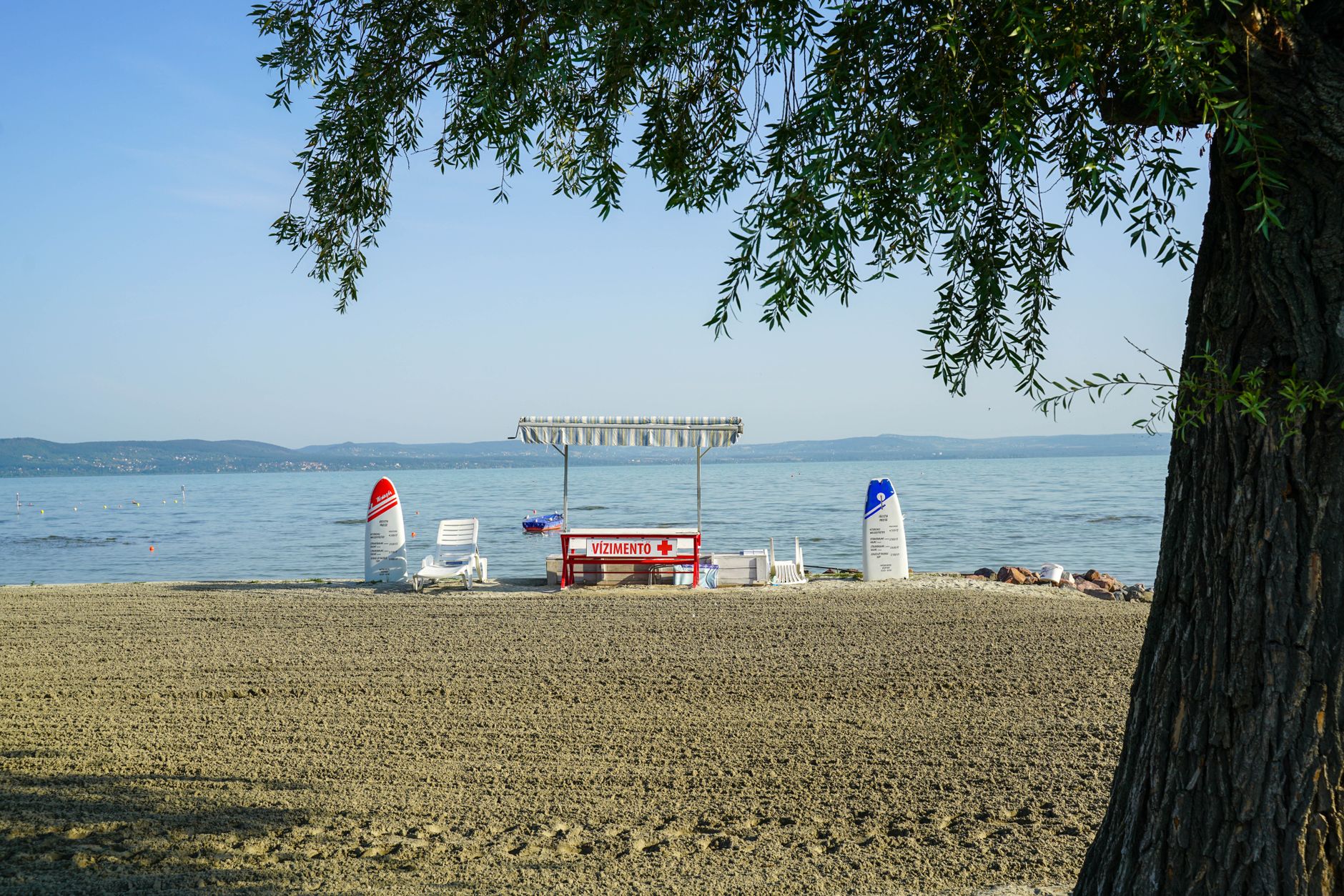 Peaceful beach with lifeguard kiosk and sun loungers at Lake Balaton, Hungary.