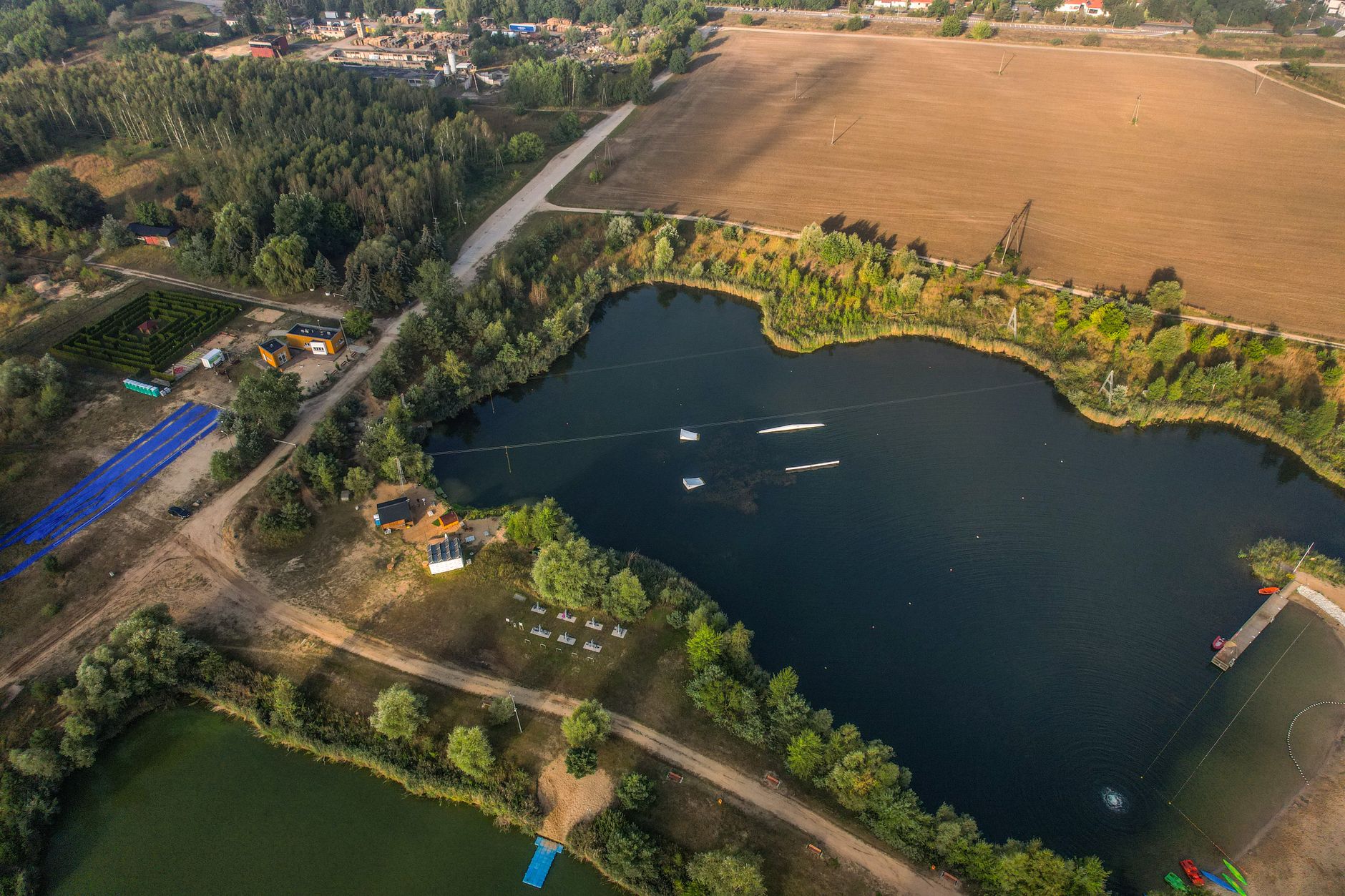 Aerial shot of a lake surrounded by fields and trees. Perfect for environmental themes.