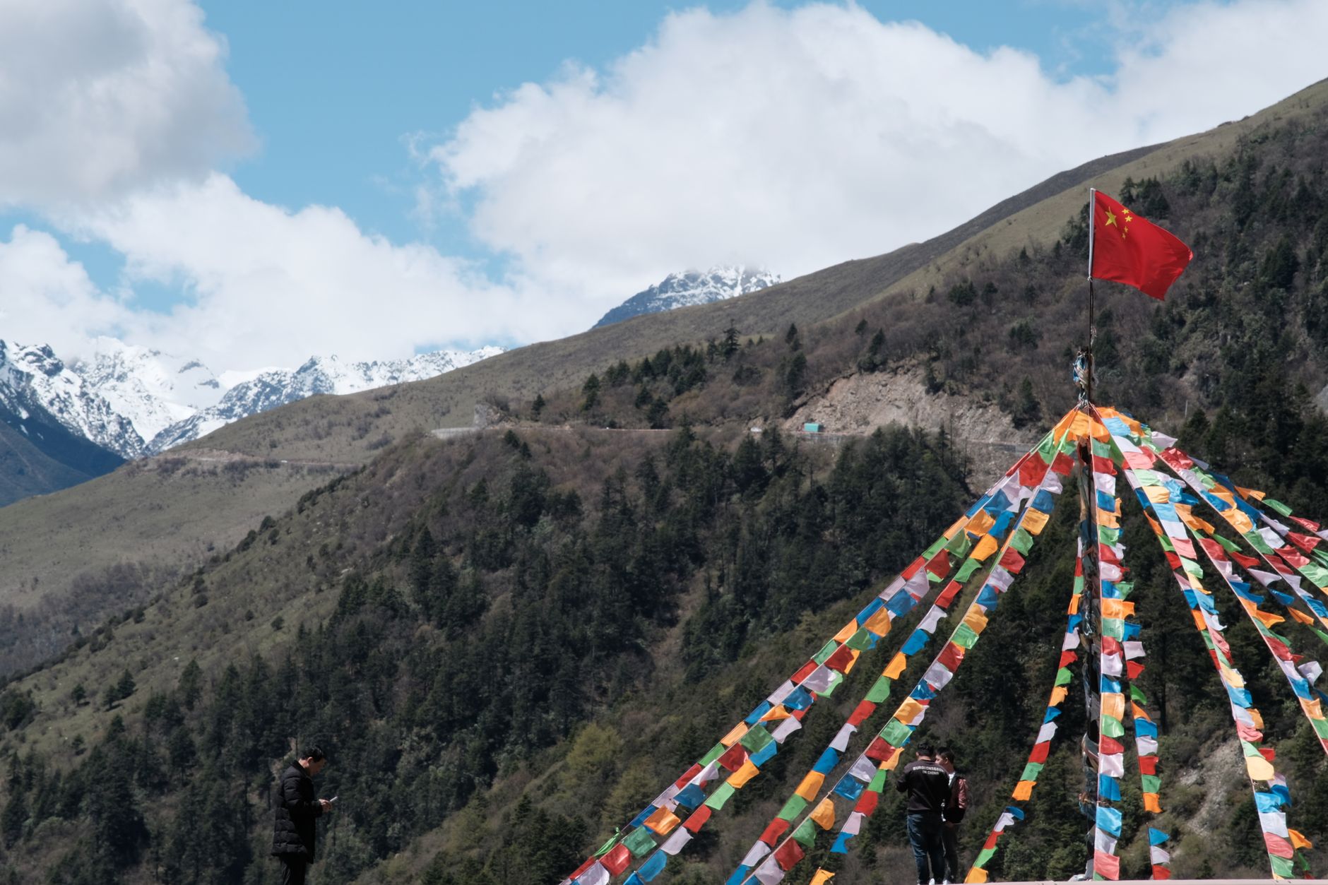 Vibrant prayer flags with a mountainous landscape, showcasing cultural and natural beauty.