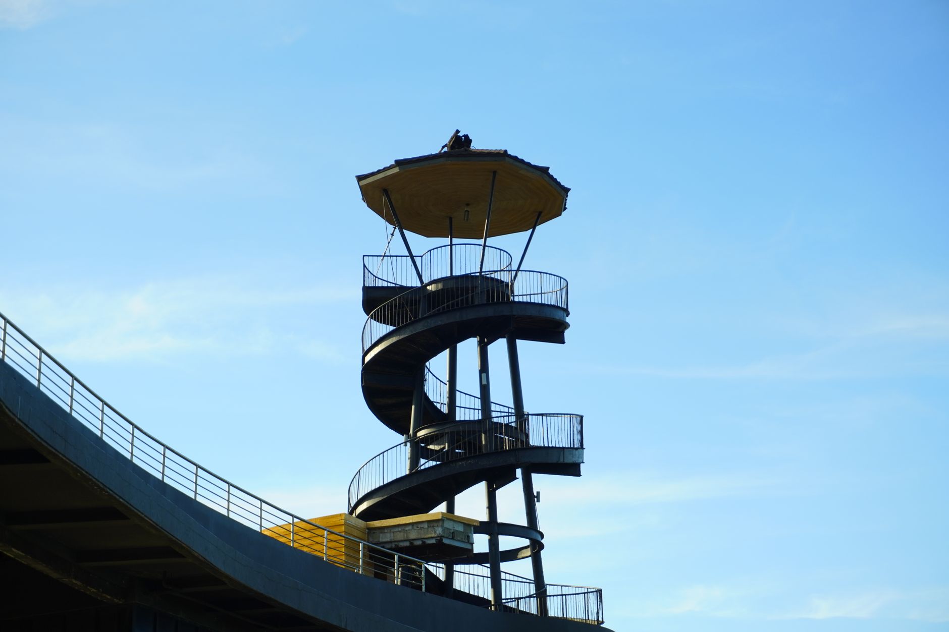 A striking spiral observation tower silhouetted against a clear blue sky, ideal for architectural themes.