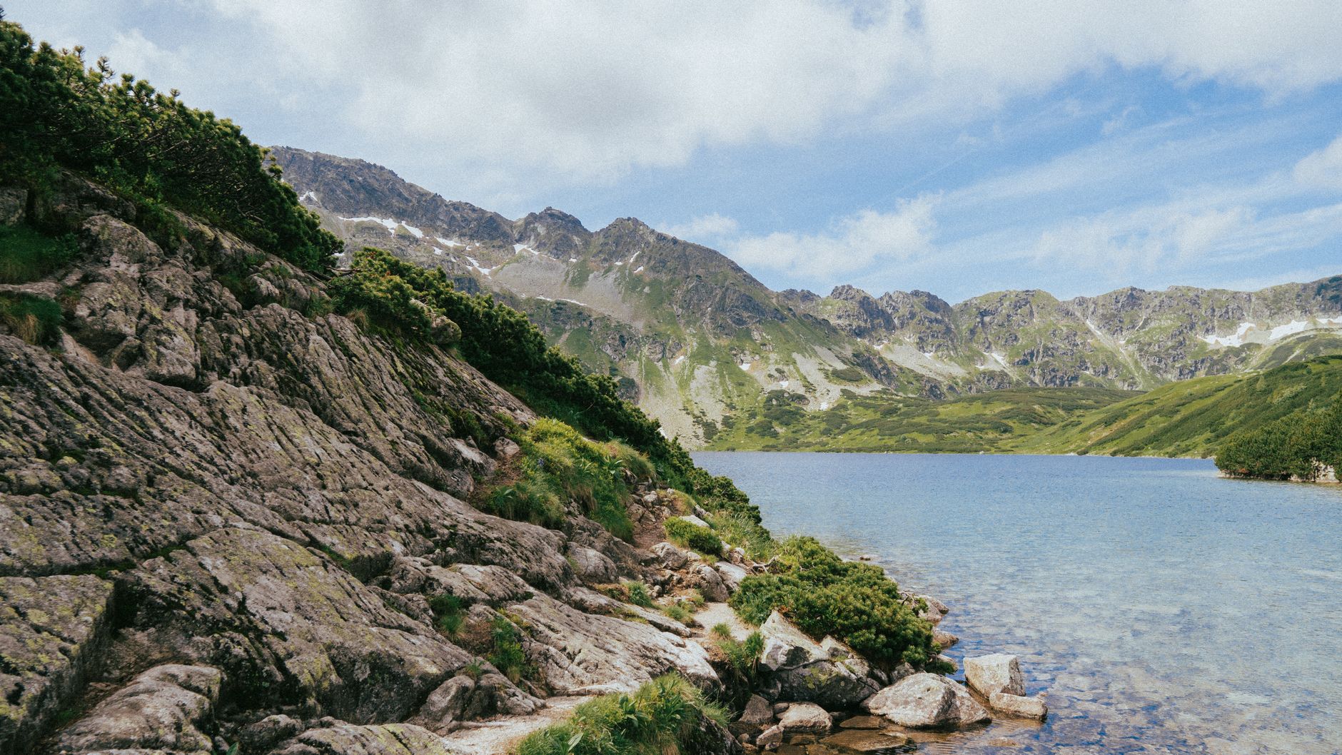 Breathtaking summer landscape featuring mountains and a serene lake in the Tatra Mountains.