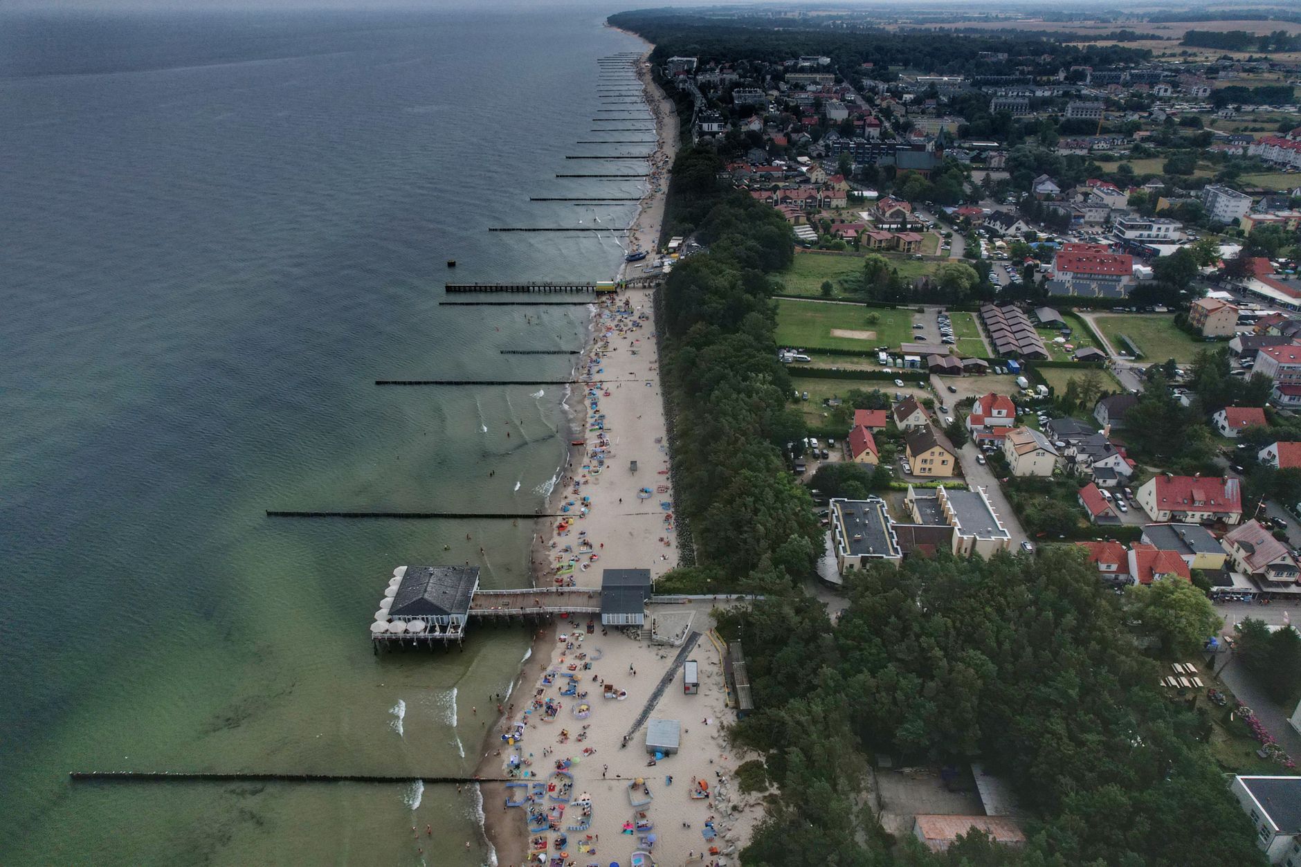 Stunning aerial view of a bustling beachfront and town during summer.