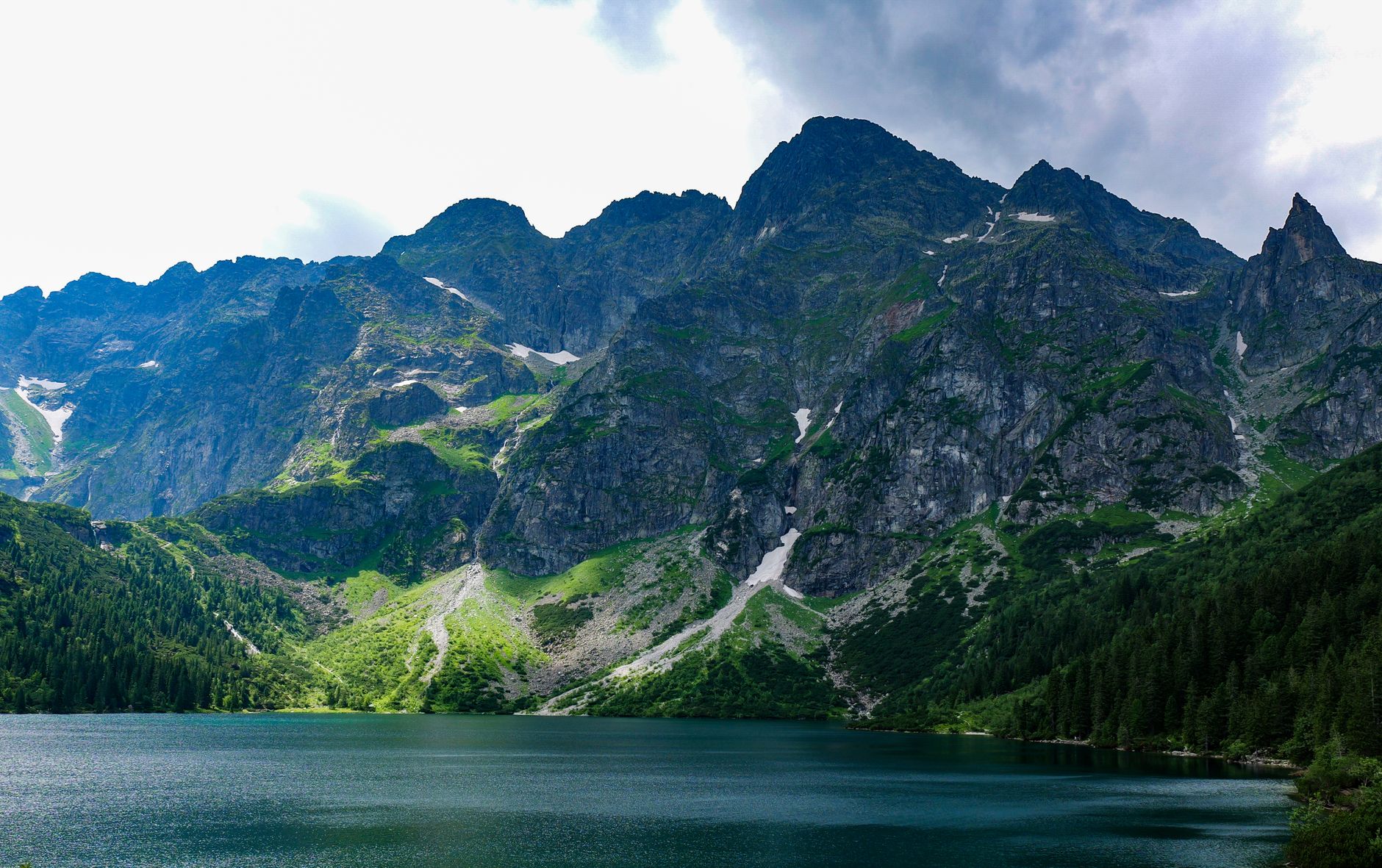 Majestic view of Tatra Mountains reflecting on a tranquil lake in Zakopane, Poland.