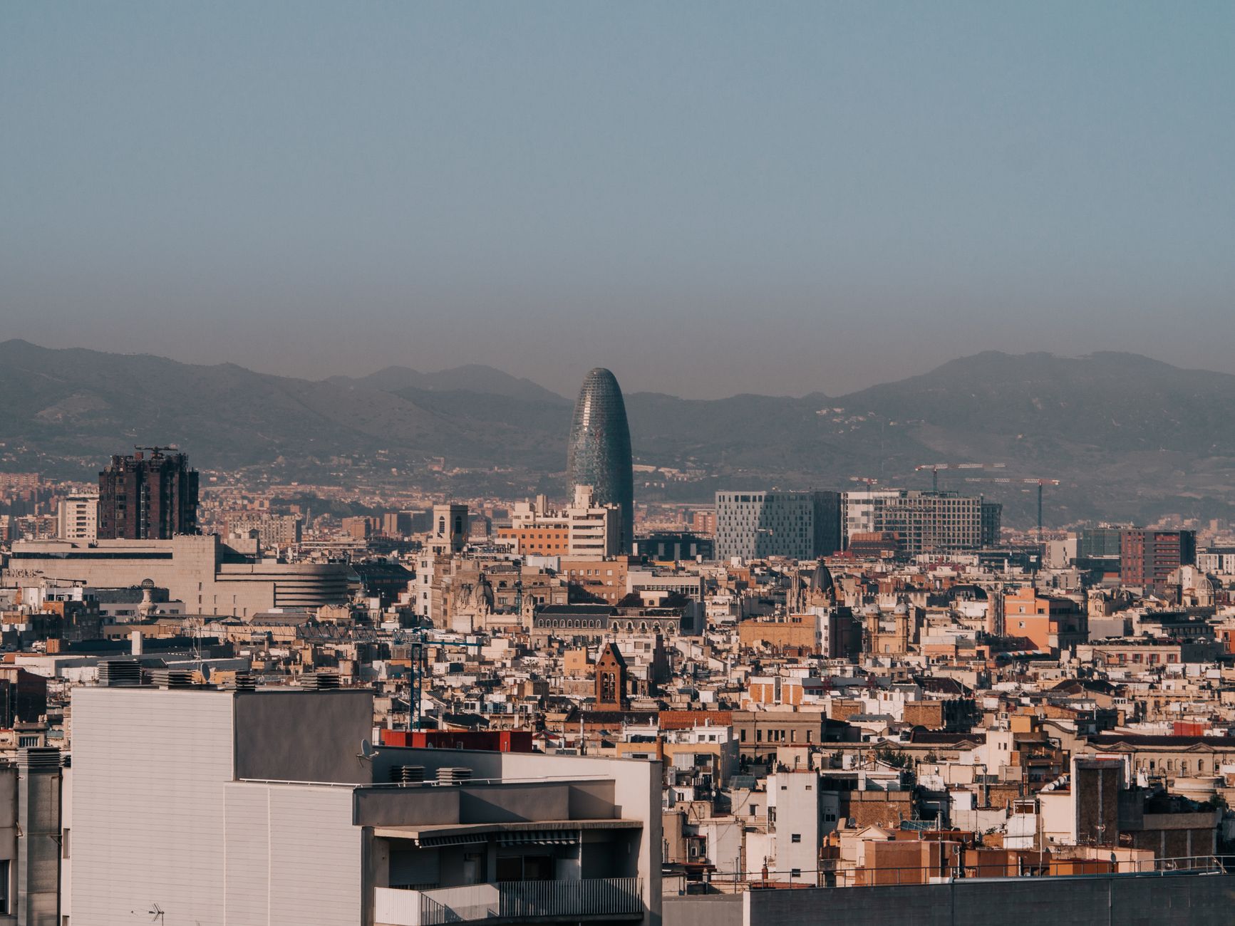 A panoramic view of Barcelona's skyline with Torre Glòries during a clear morning.