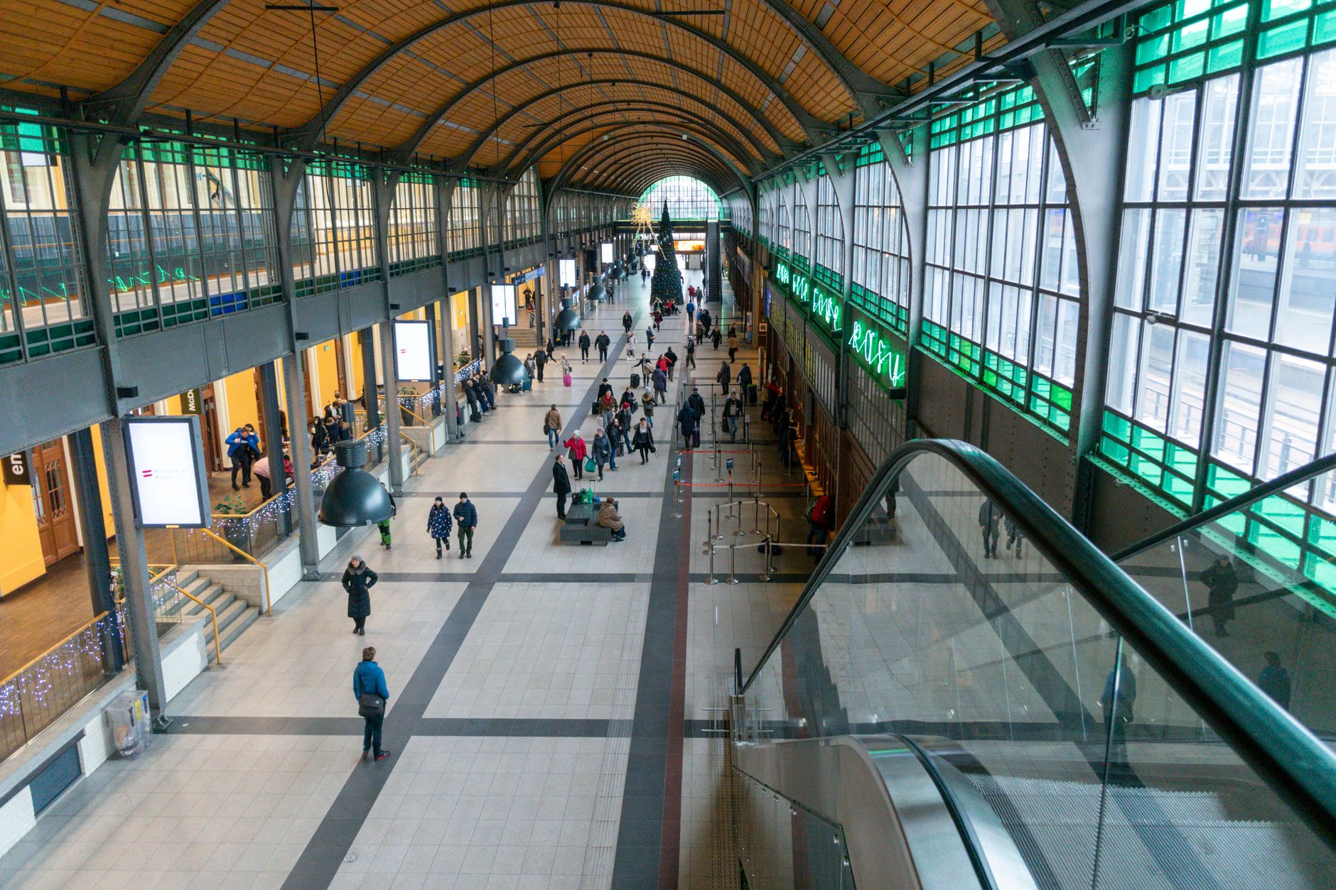 Wrocław train station interior with people and Christmas decorations.