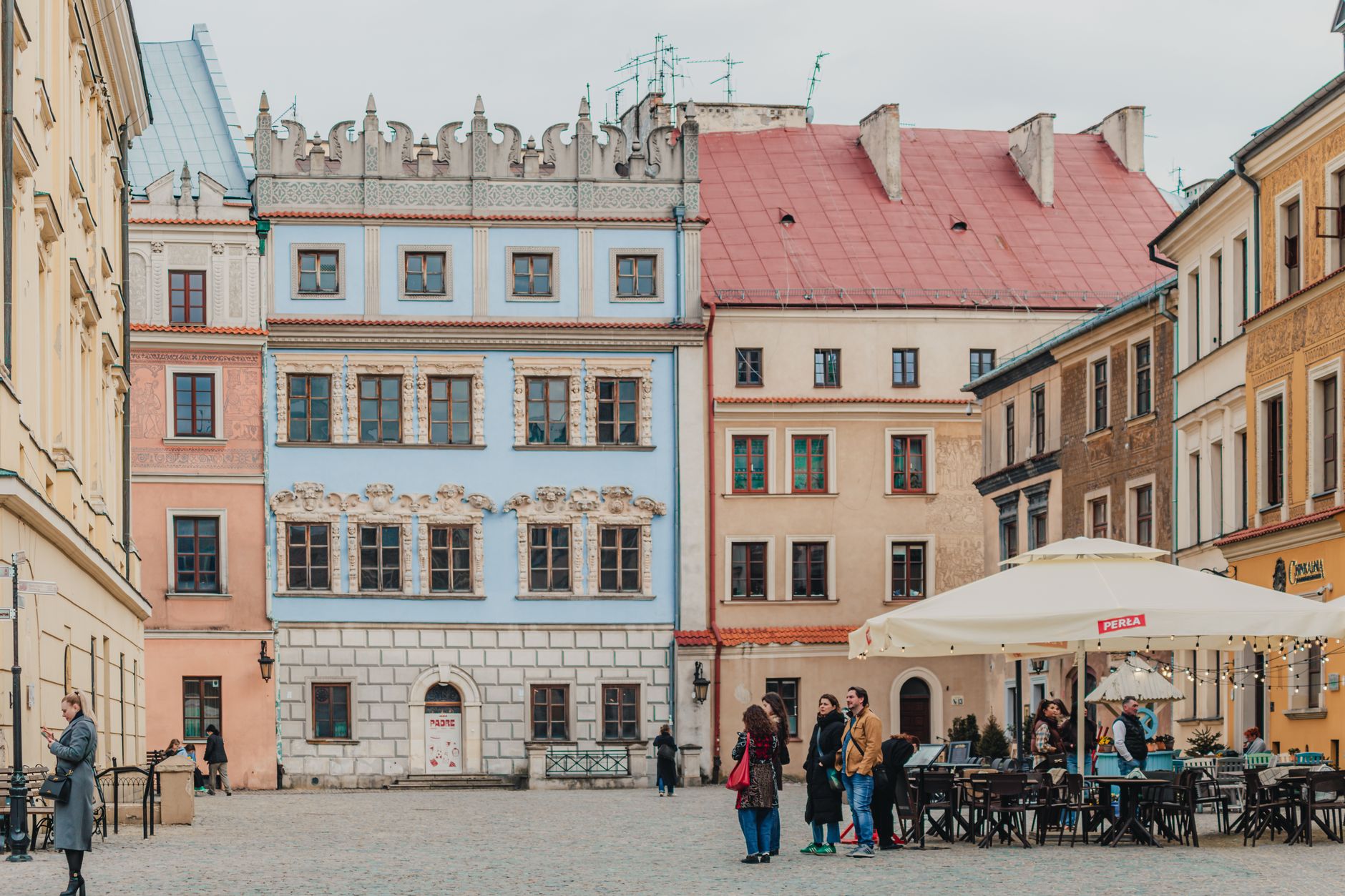 Picturesque square with colorful historic buildings and outdoor cafes in Lublin's Old Town.