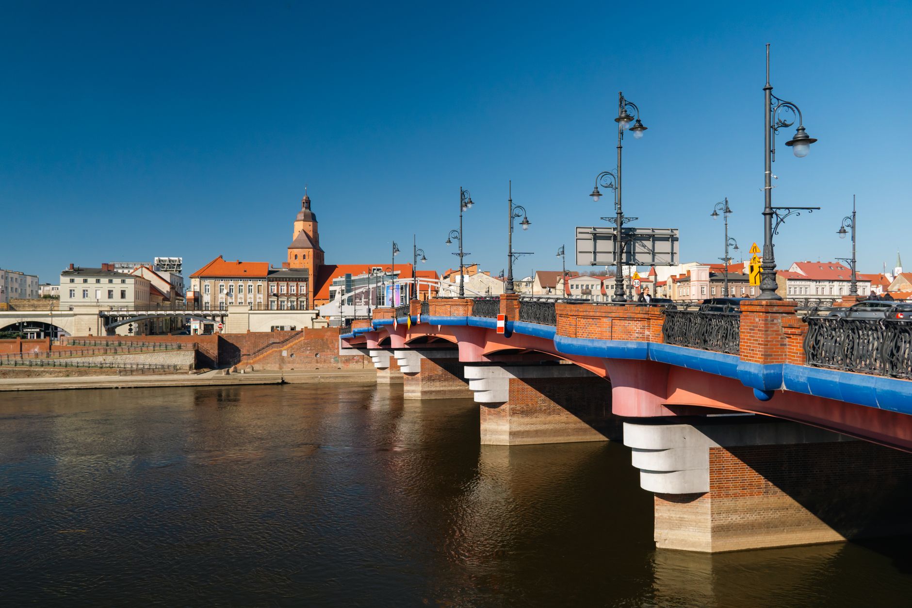 Scenic view of the historic red bridge in Gorzów Wielkopolski under a clear blue sky.
