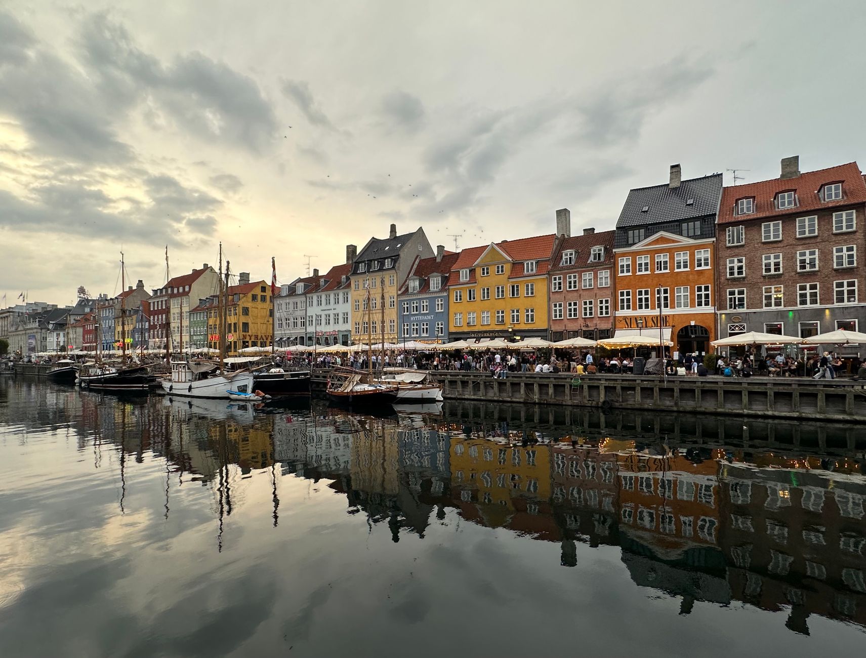 Picturesque view of Nyhavn's colorful buildings along the canal in Copenhagen, Denmark during evening hours.