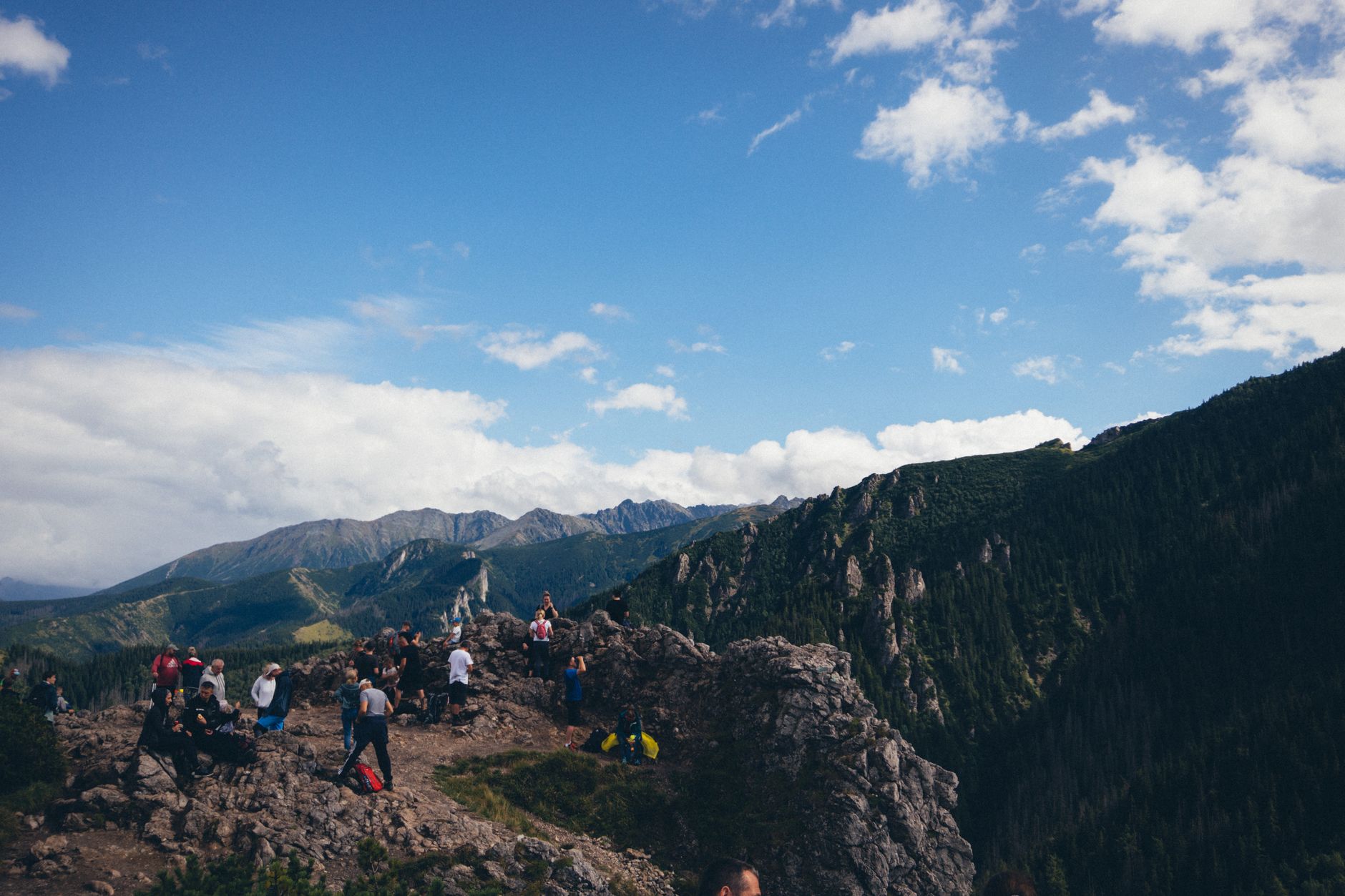 Hikers enjoying a scenic view atop Sarnia Skala in the Tatra Mountains, Poland.