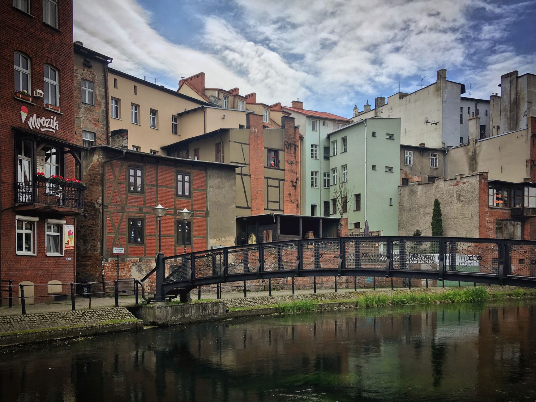 Picturesque view of historic buildings and footbridge in Bydgoszcz, Poland, reflecting urban charm.