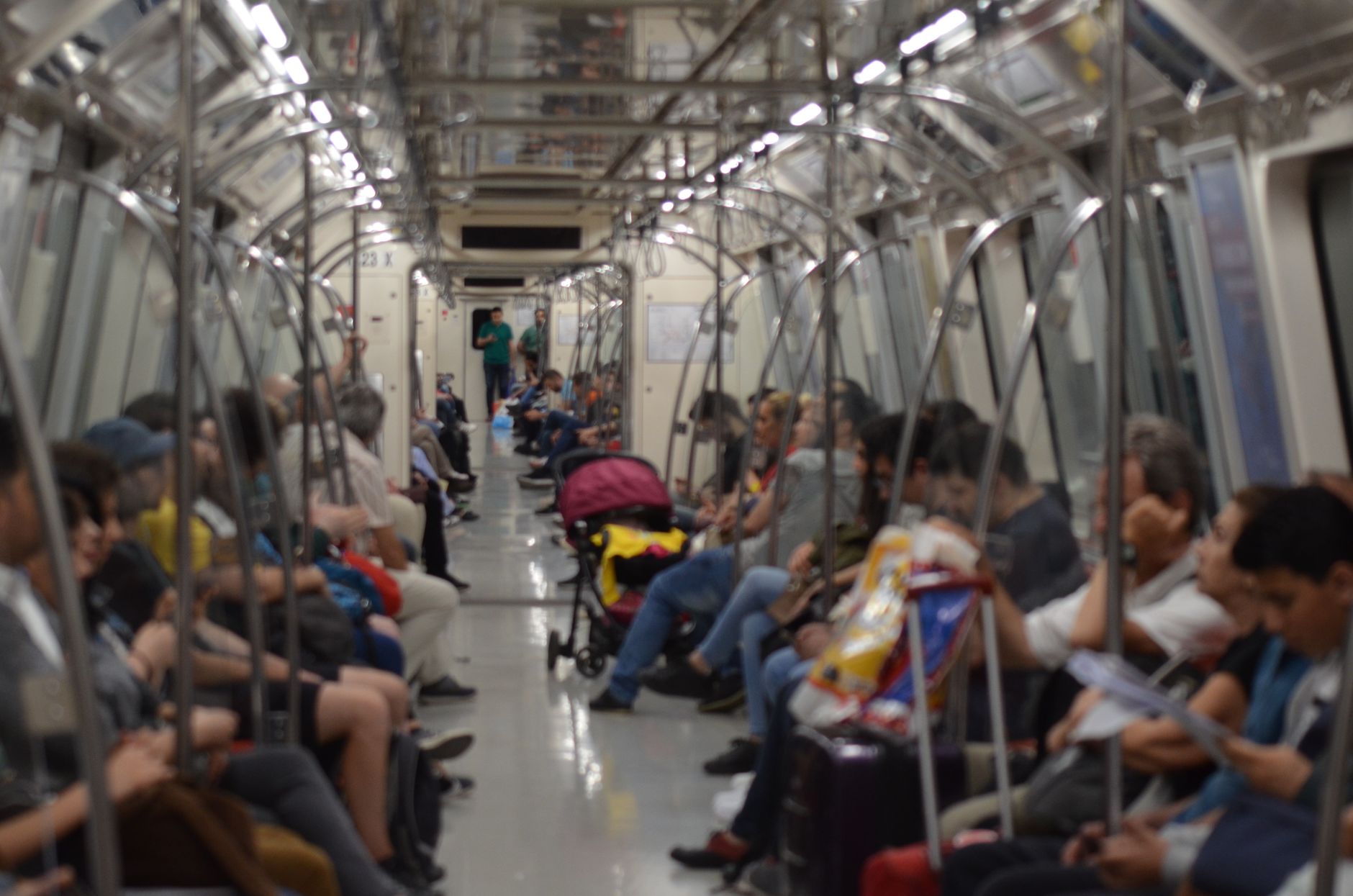 A crowded subway car filled with diverse commuters traveling through an urban area.