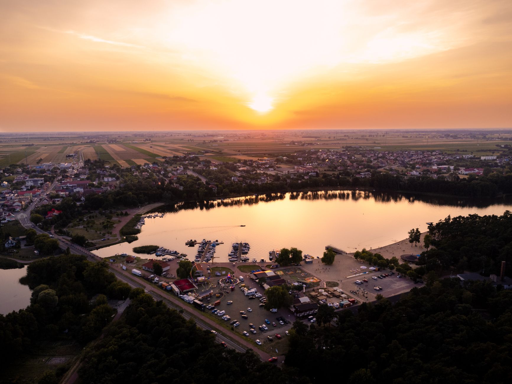A beautiful aerial view of Lake Ślesin, capturing the stunning sunset and vibrant landscape of Ślesin, Poland.