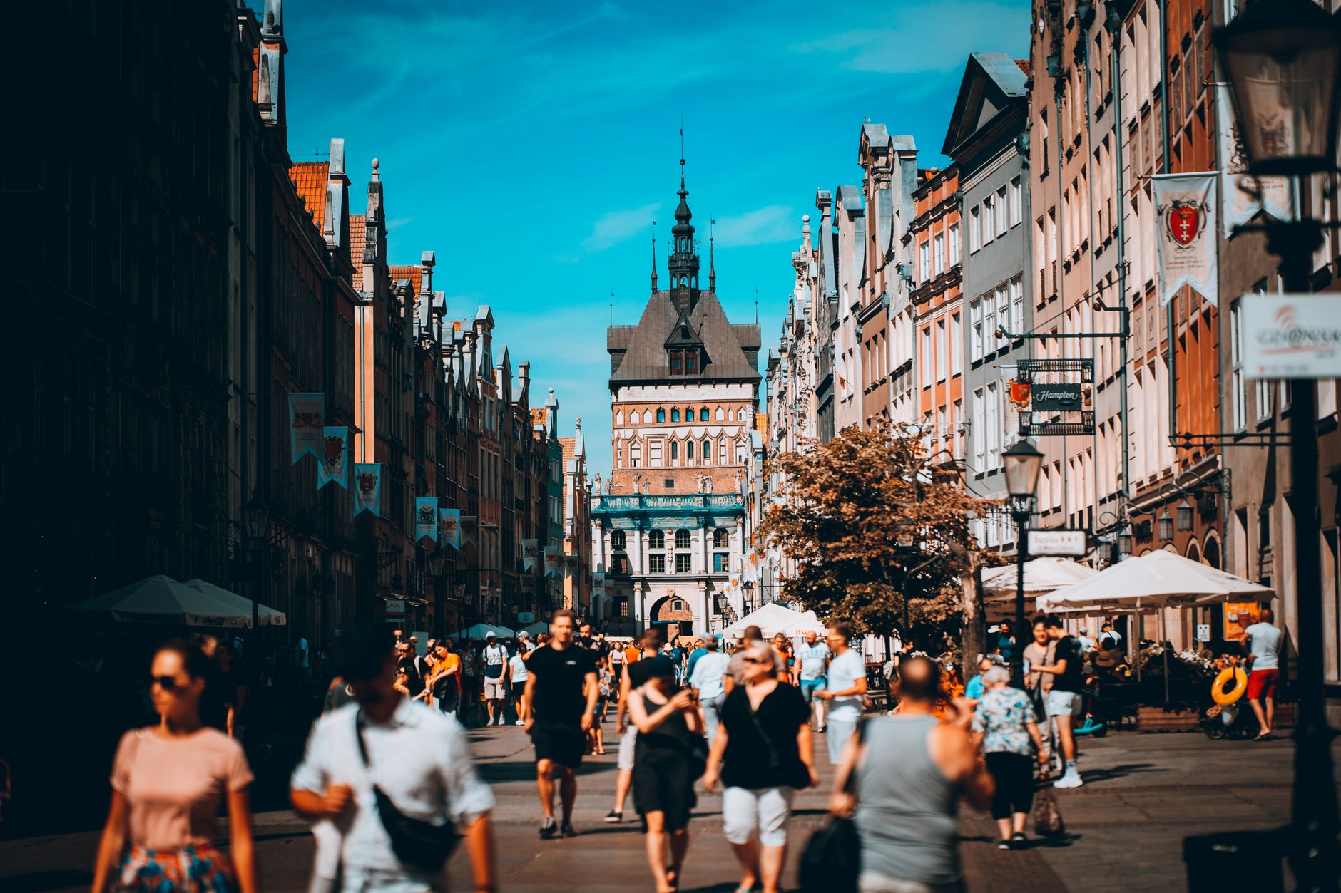 Vibrant street scene in Gdańsk's old town with people enjoying a sunny day in summer.