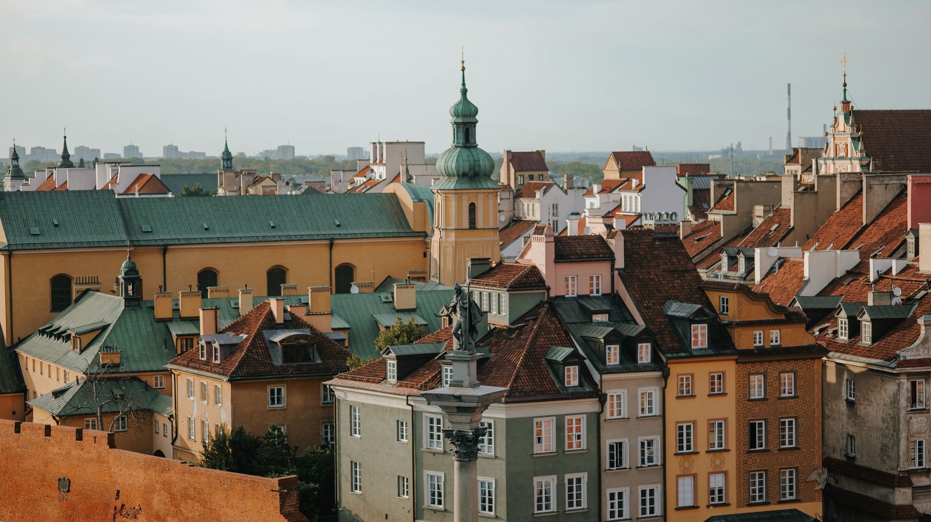 Charming panoramic view of Warsaw Old Town's colorful rooftops and classic architecture under a clear sky.