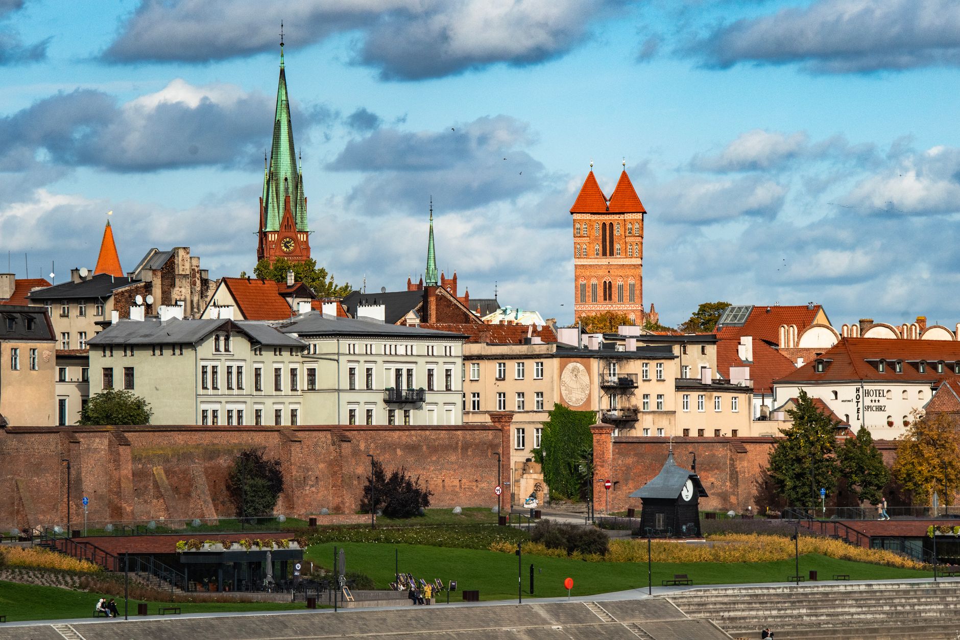 Charming cityscape of Torun, Poland, showcasing medieval architecture and vibrant rooftops under a bright sky.