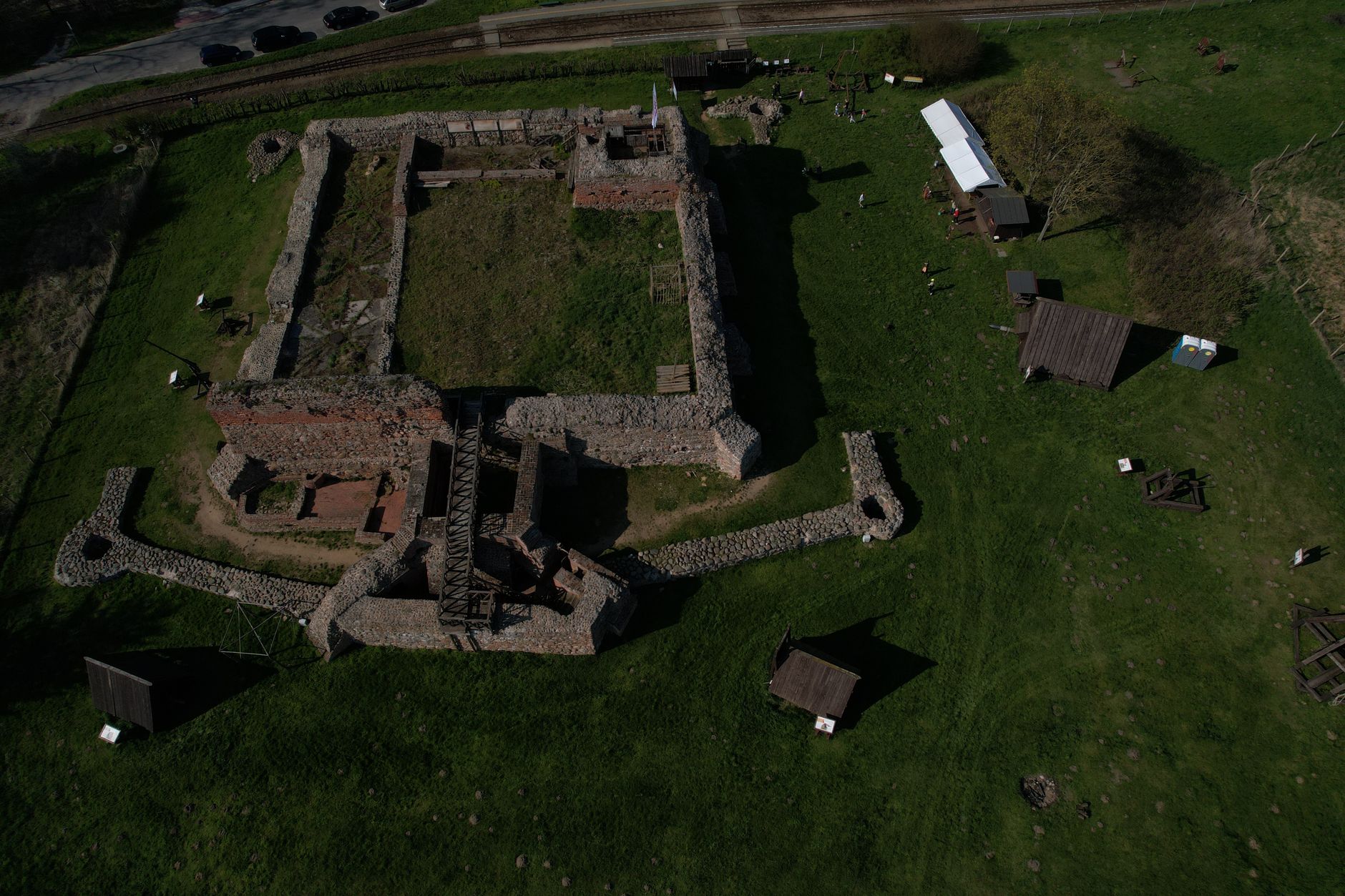 Aerial view of historic fortification ruins surrounded by green grass.