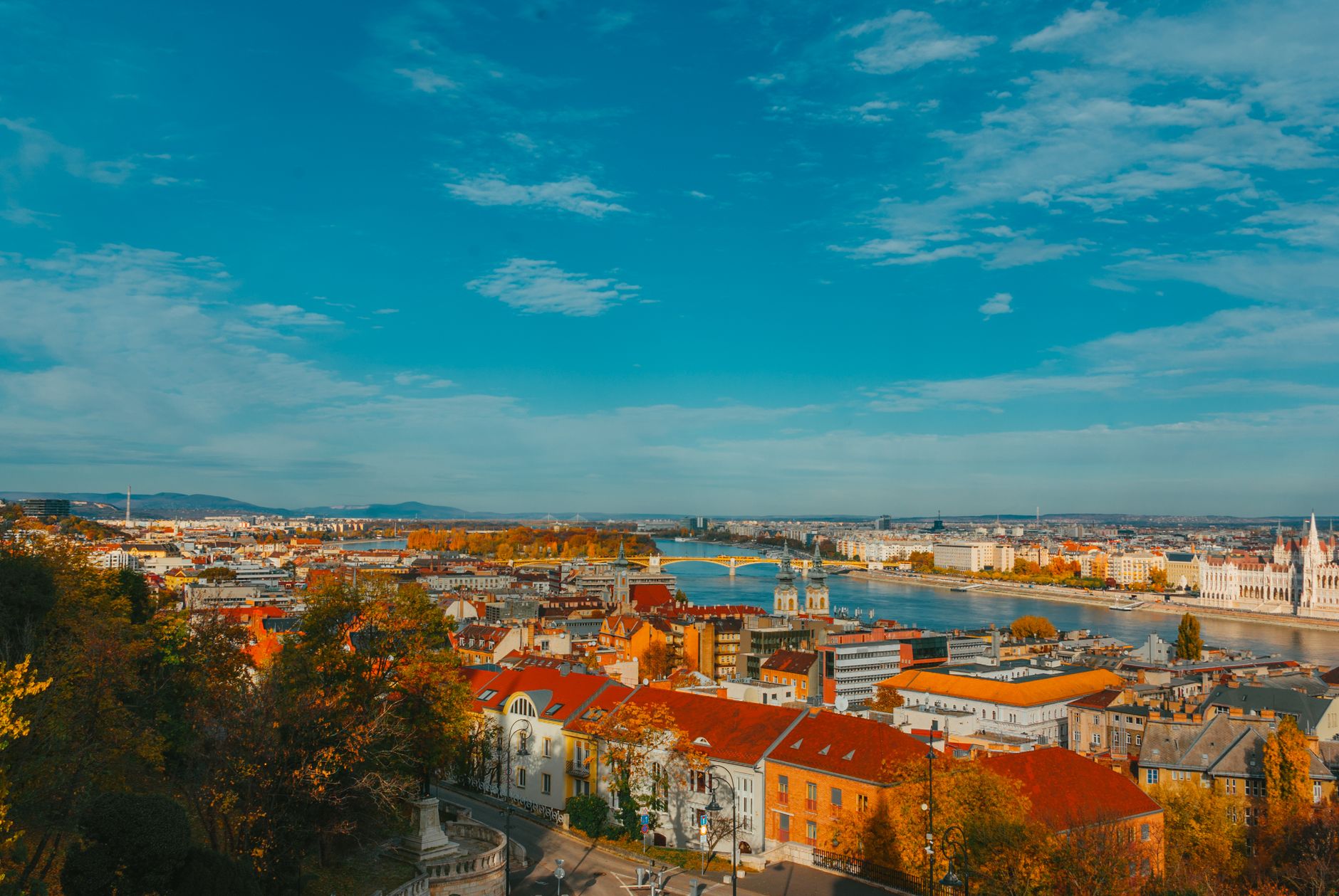 Explore the vibrant autumn scenery of Budapest with its iconic Parliament and Danube River.
