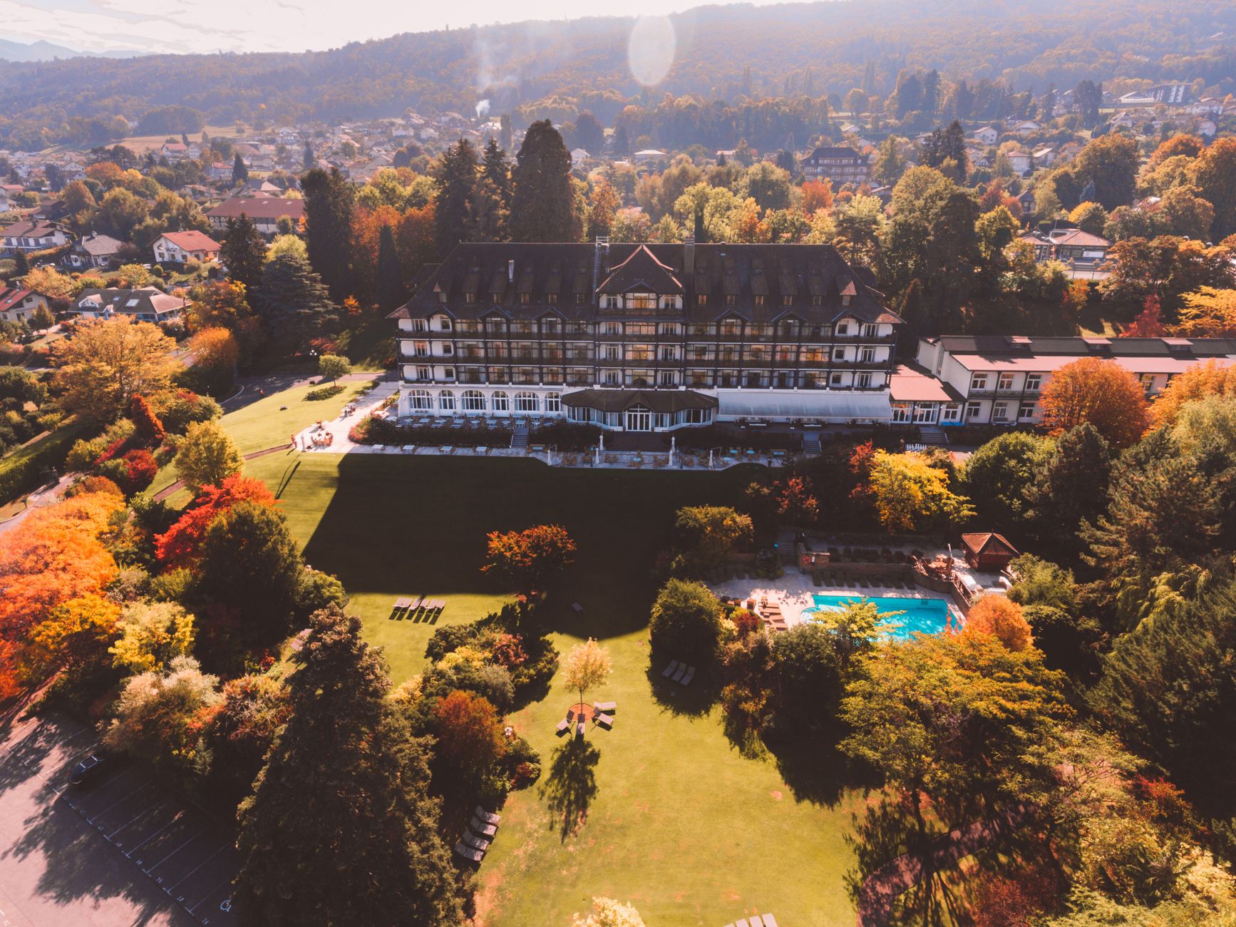 Stunning aerial shot of a historic hotel amidst vibrant fall foliage.
