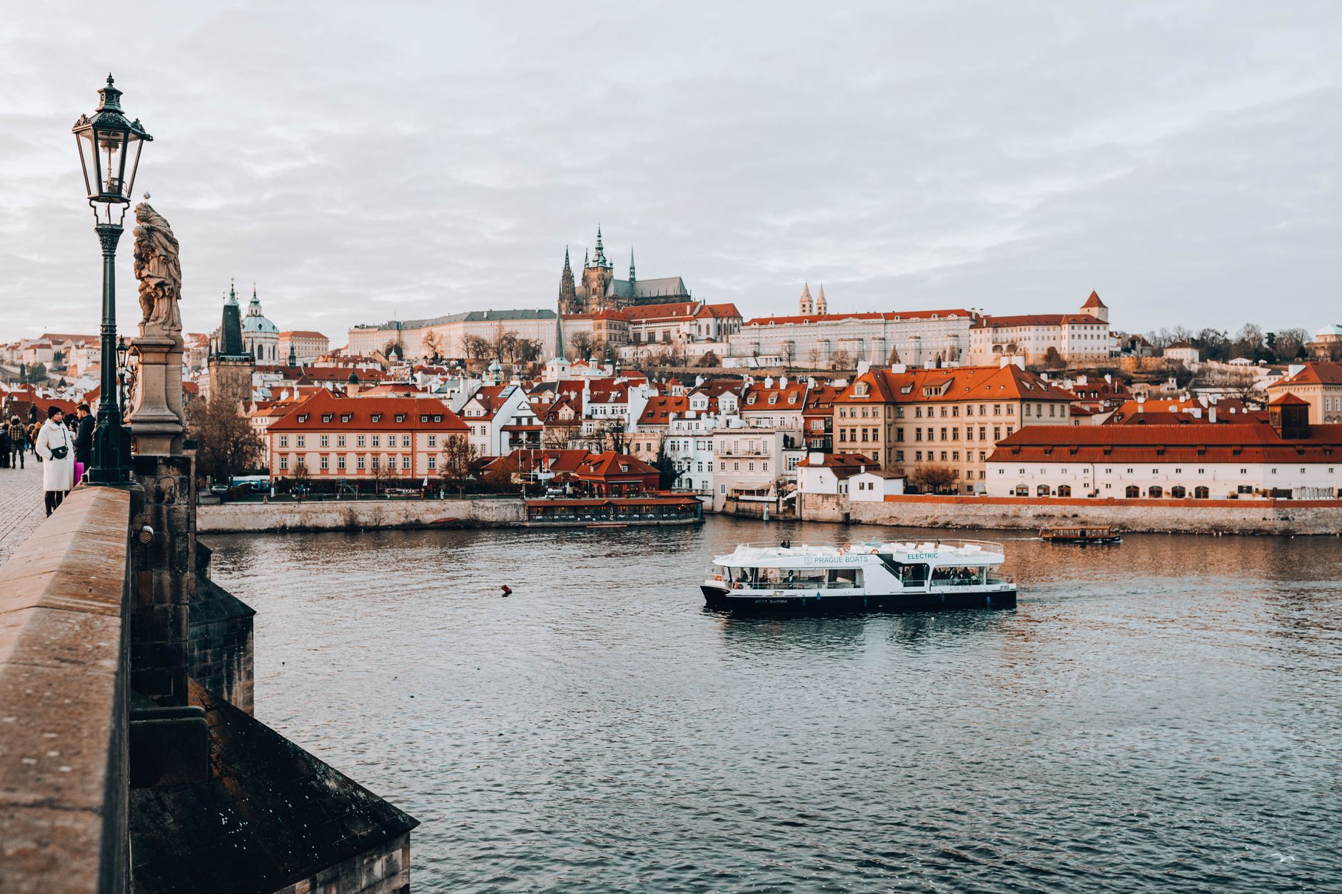 Scenic view of Prague Castle and Vltava River from Charles Bridge in autumn.