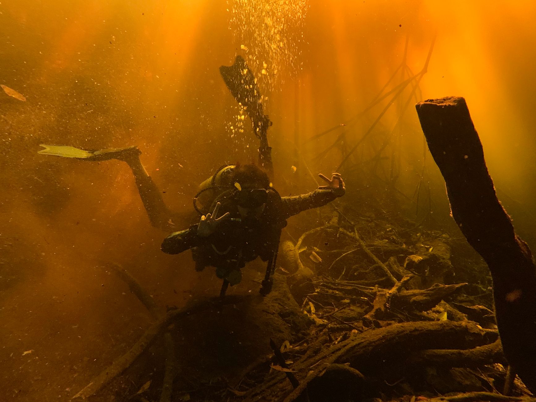 Scuba diver exploring a sunlit underwater landscape with vibrant hues.