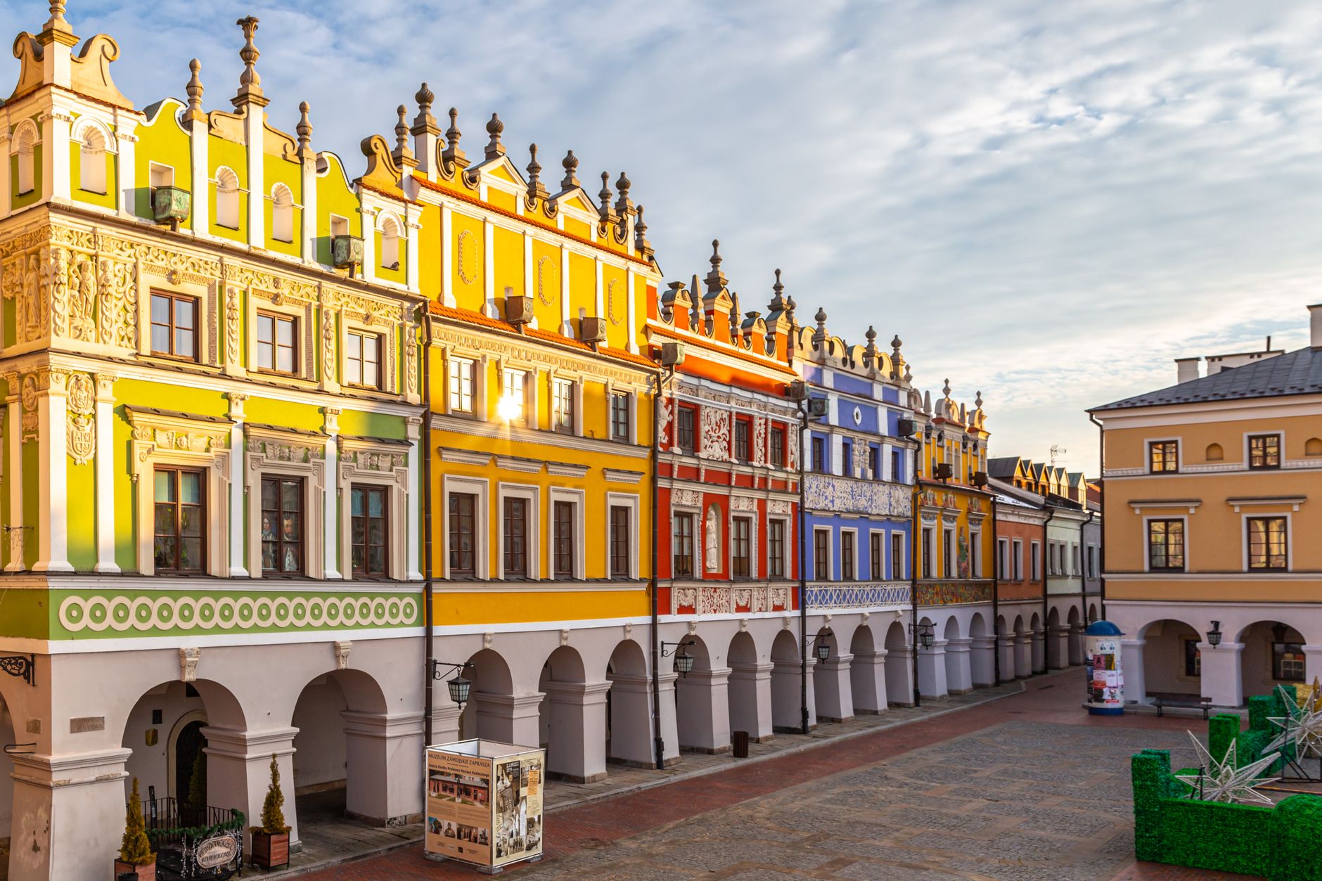 Vibrant Renaissance facades and arches in Zamość's historic market square, Poland.